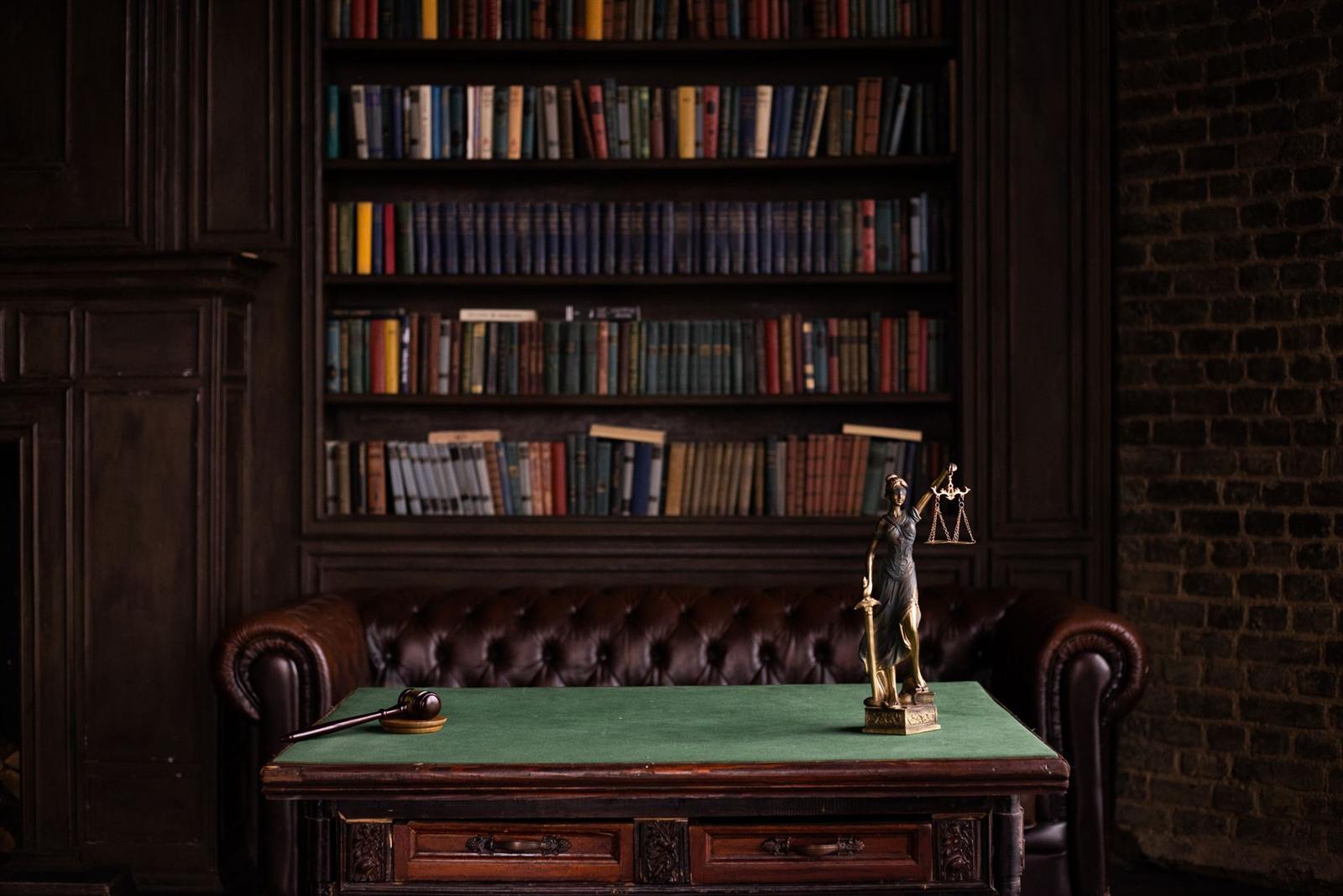 Bibliotecă juridică, statueta Justiției și birou de avocat